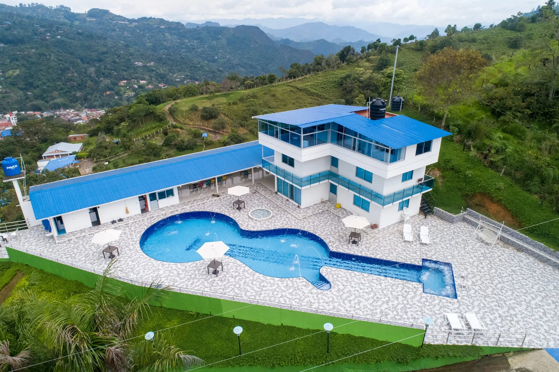 Vista aérea de finca hotel con piscina y montañas