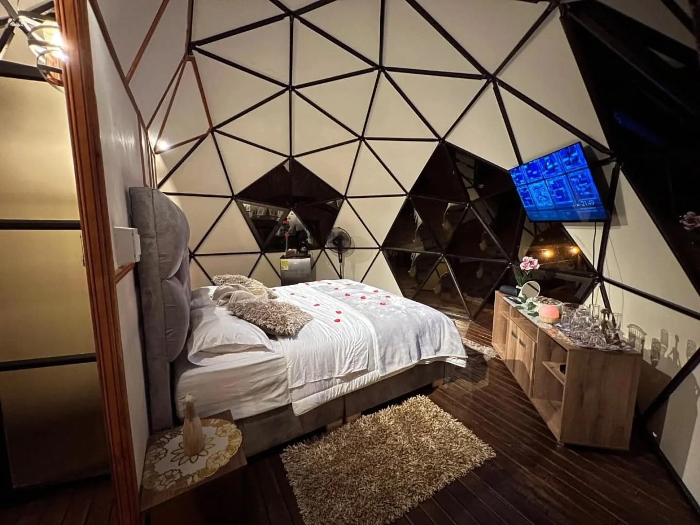 Interior del domo glamping con cama y decoración romántica